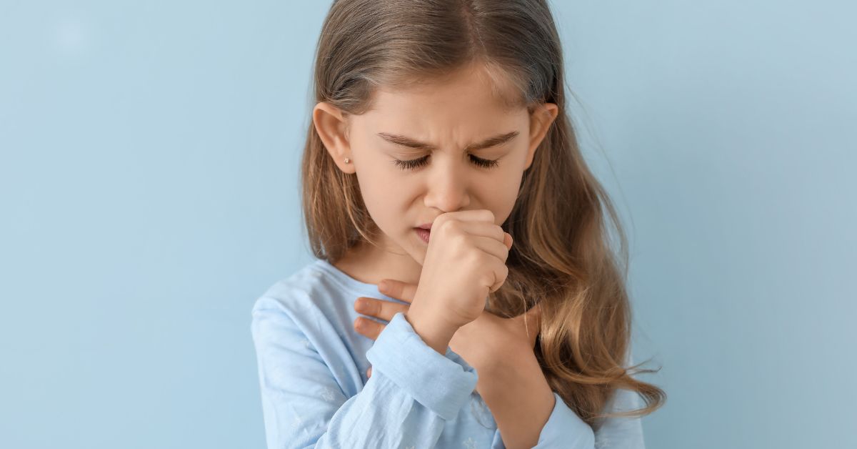 devojčica na plavoj pozadini kašlje