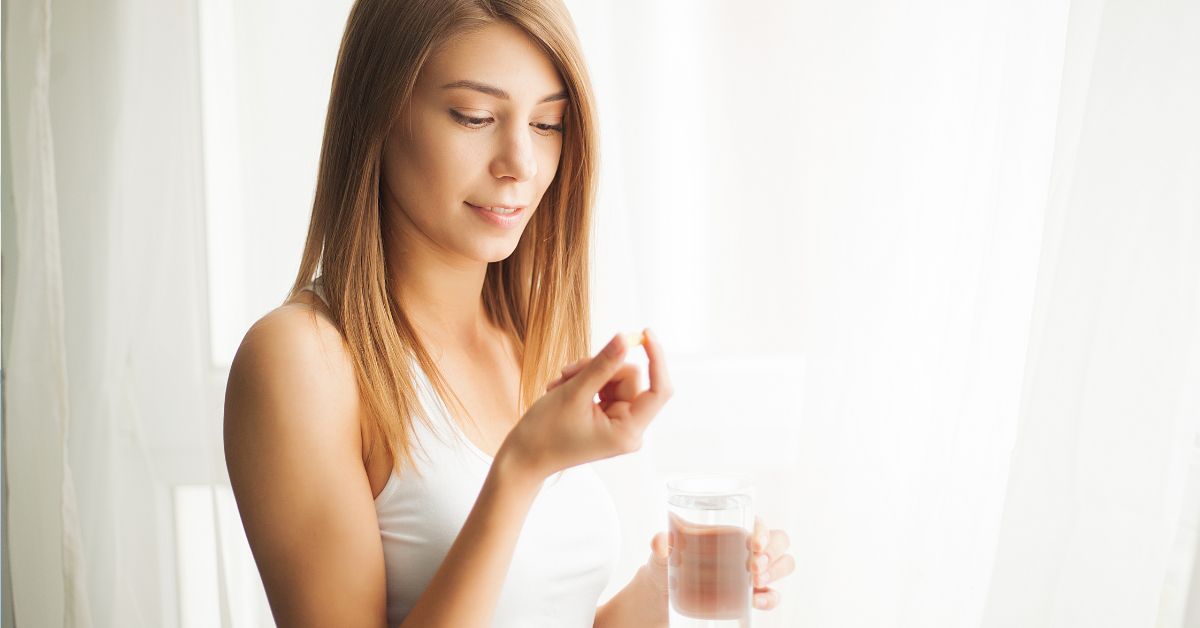 žena uzima i pije pilulu