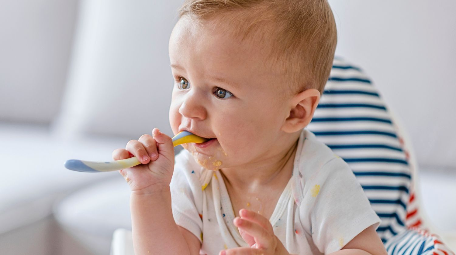 Beba drži kašičicu u ustima