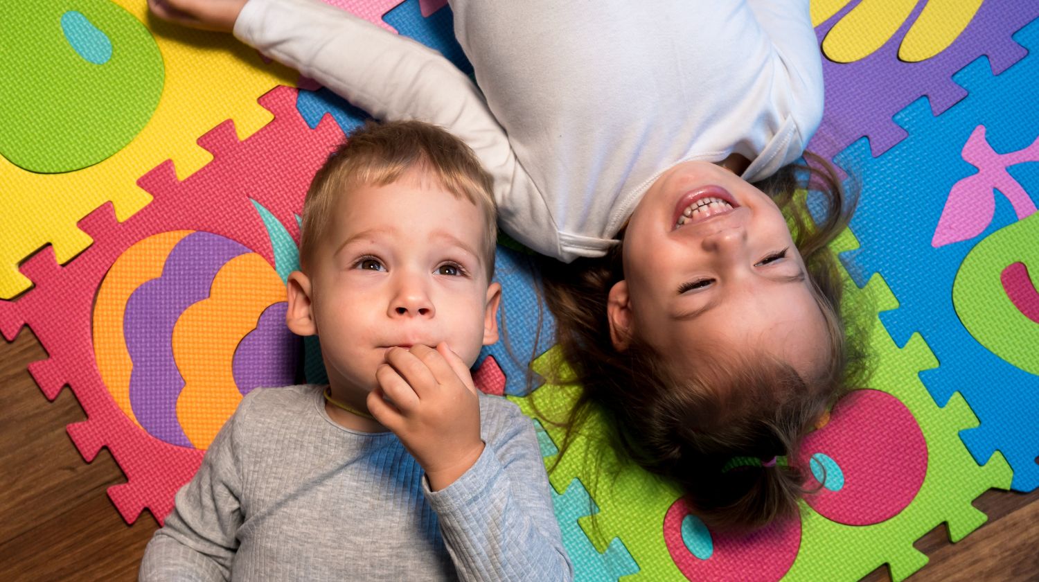 Dečak devojčica leže na šarenom podu