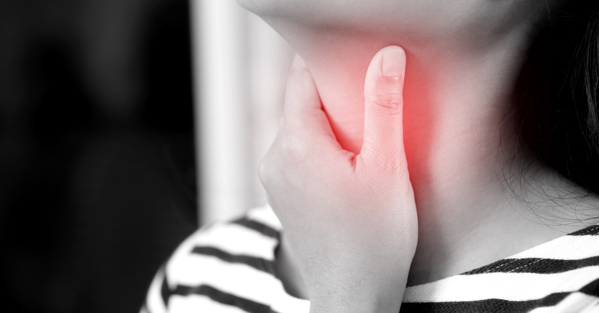 ženska ruka se drži za grlo