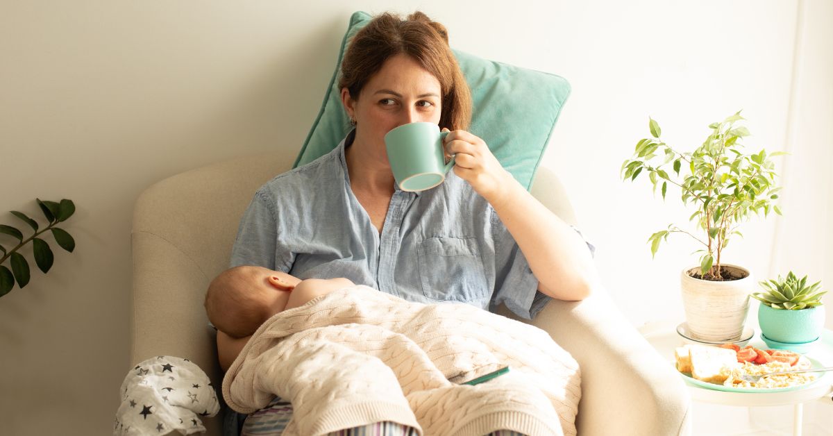 žena doji bebu i pije iz šolje