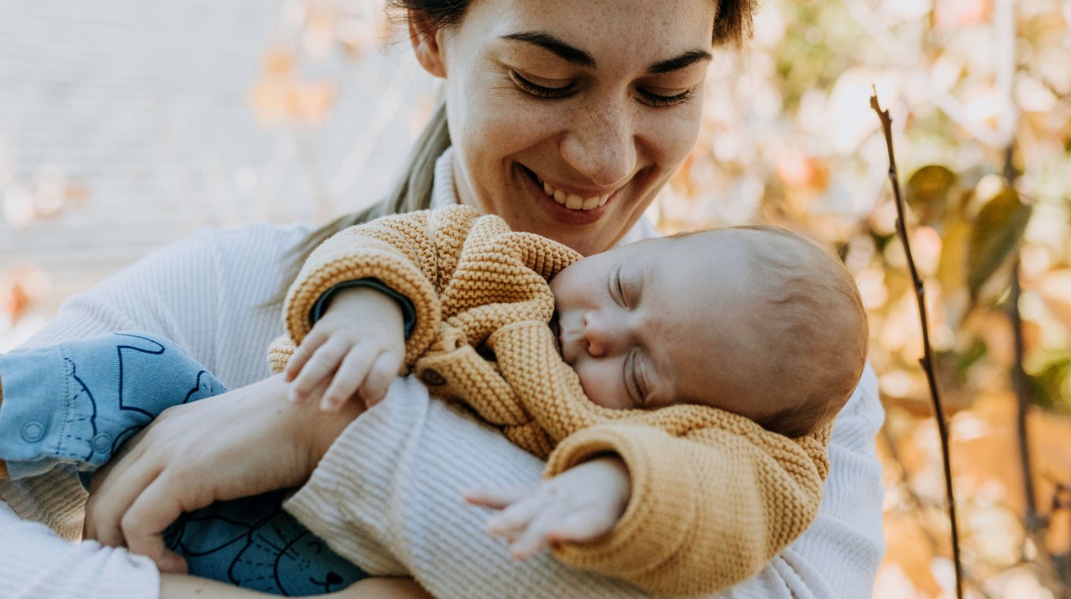 Mama drži usnulu bebu u naručju