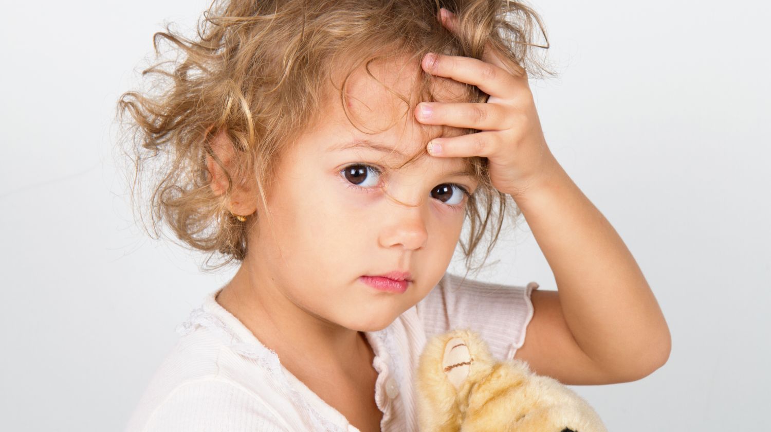 Malo dete drži se za glavu