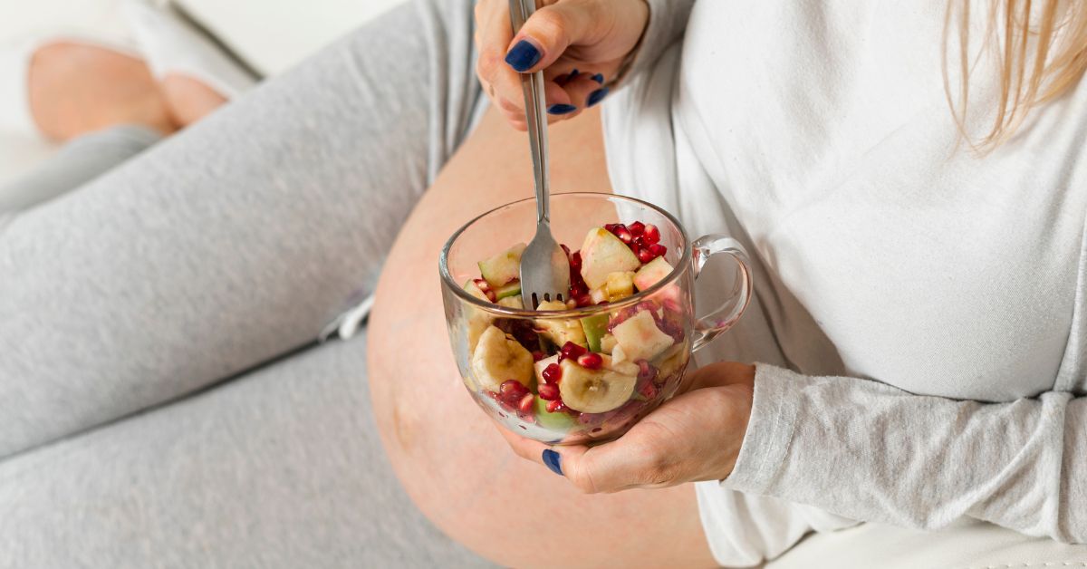 trudnica jede voćnu salatu u krevetu