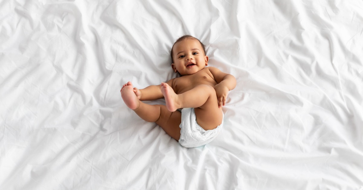 Beba leži na beloj posteljini