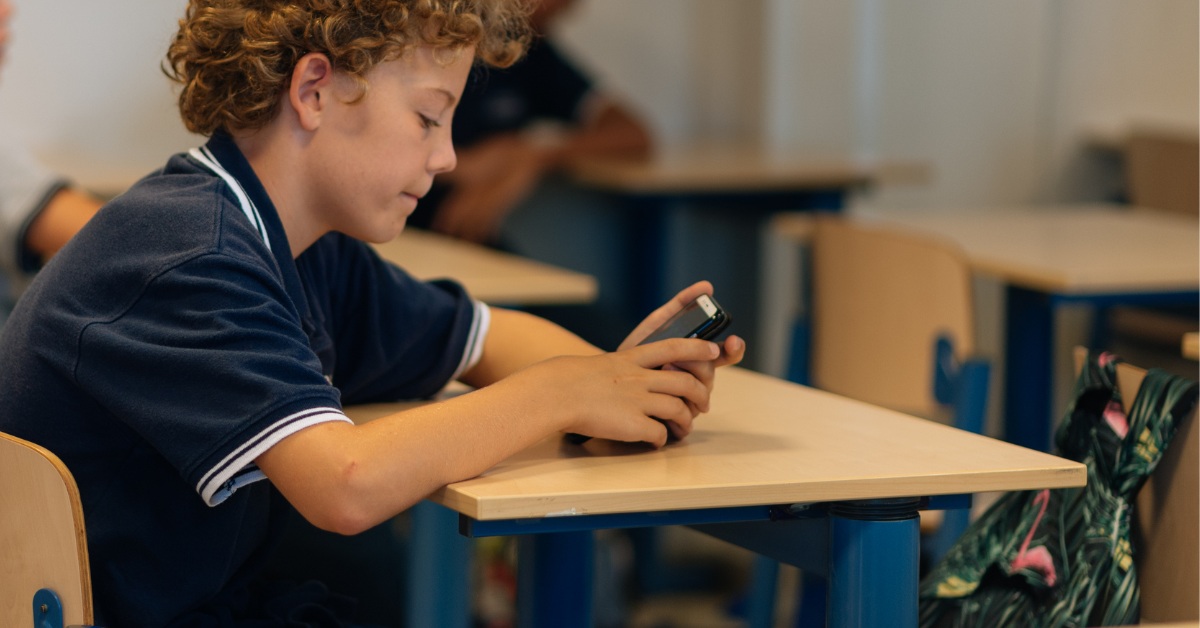 dečak gleda u telefon na času