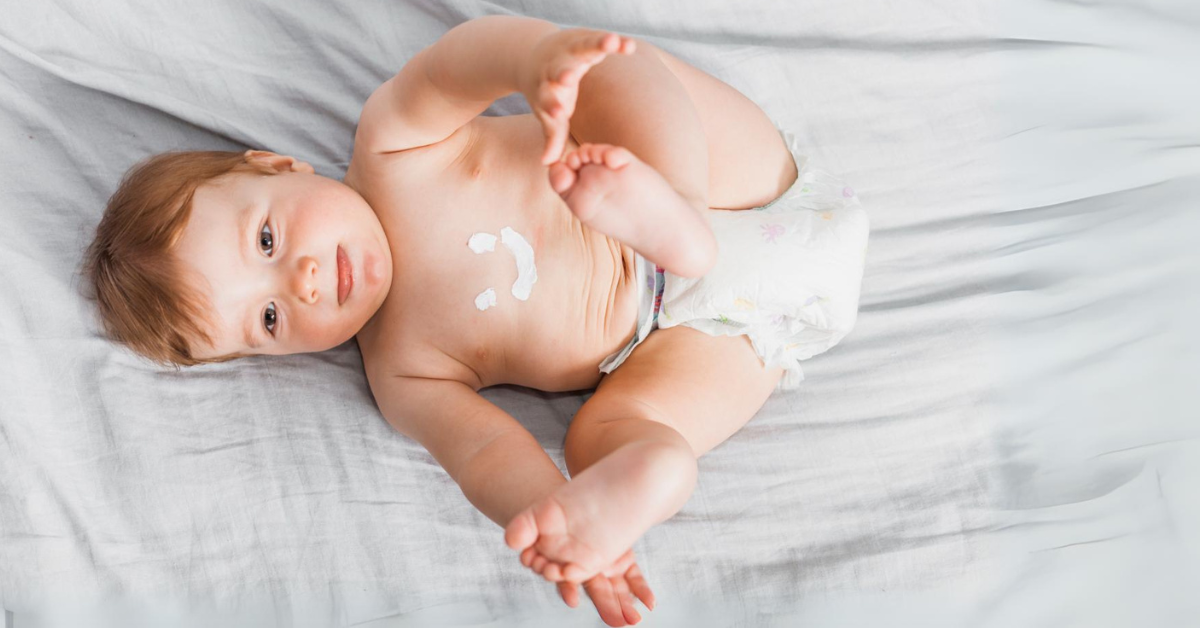 beba dečak leži na krevetu u peleni