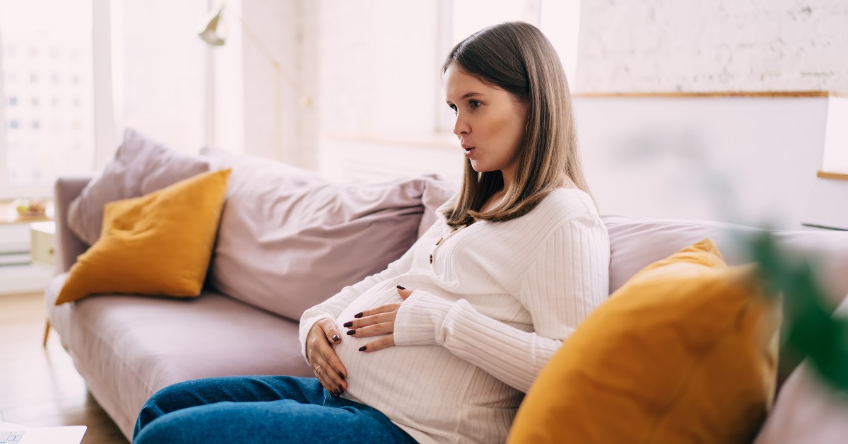 trudnica sedi na kauču i diše