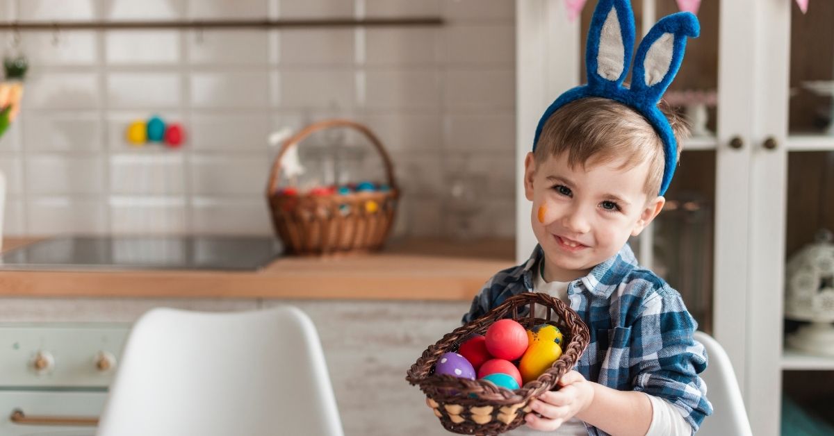 Dečak drži korpicu sa uskršnjim jajima