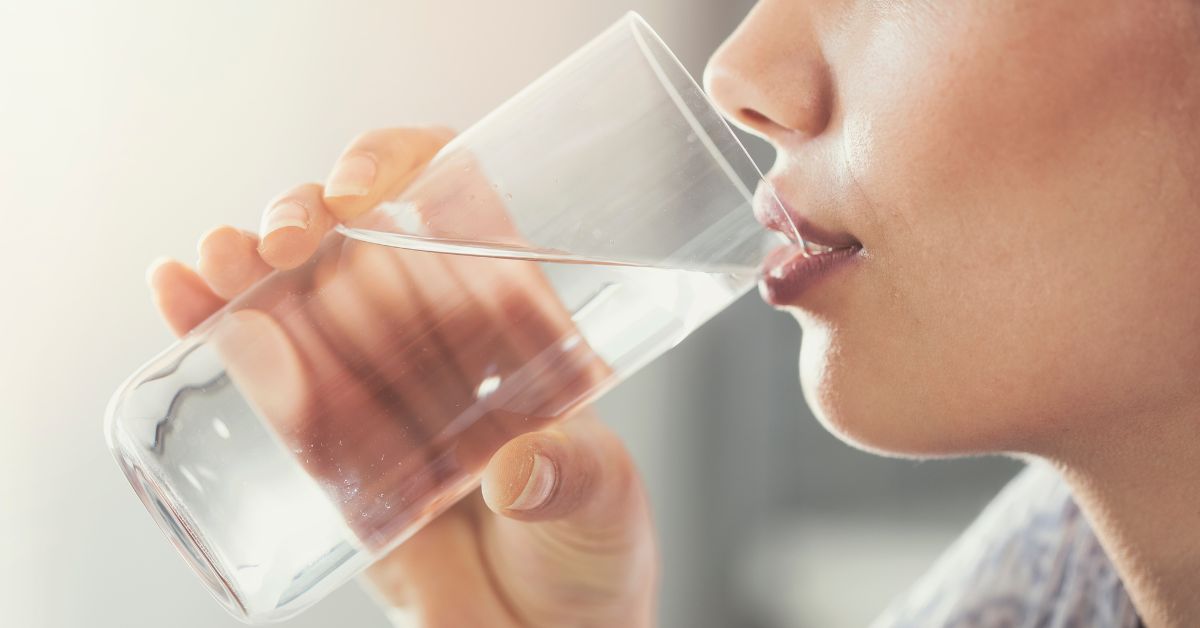 Žena pije vodu iz čaše