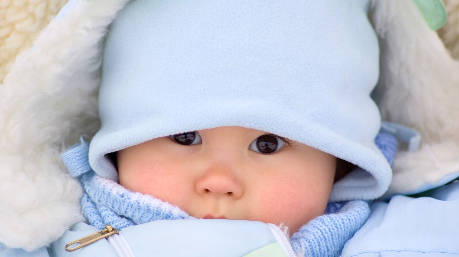 Beba sa plavom kapicom na glavi