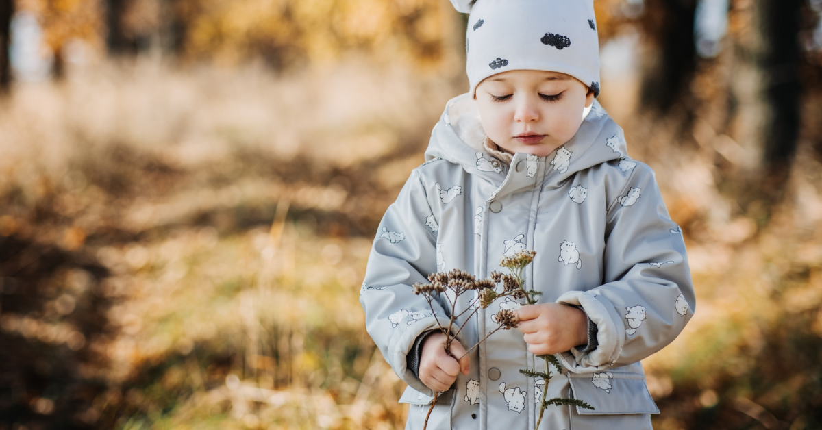 dete napolju drži graničicu kapa i jakna