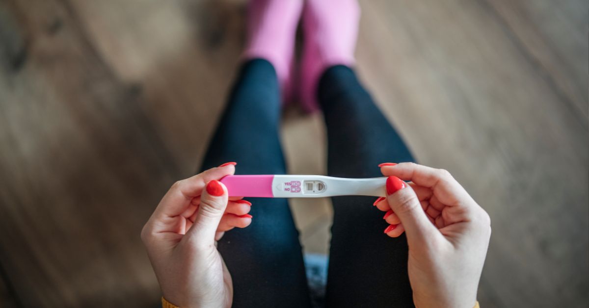 Žena drži pozitivan test za trudnoću