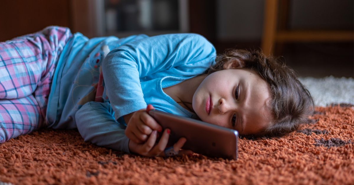 Devojčica gleda mobilni telefon