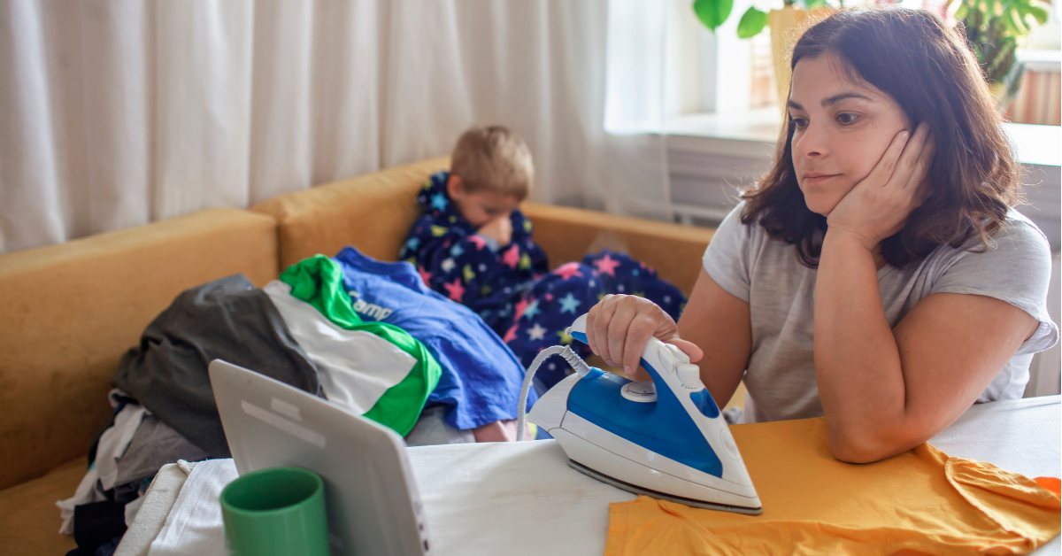 mama pegla majicu a dečak sedi iza na kauču