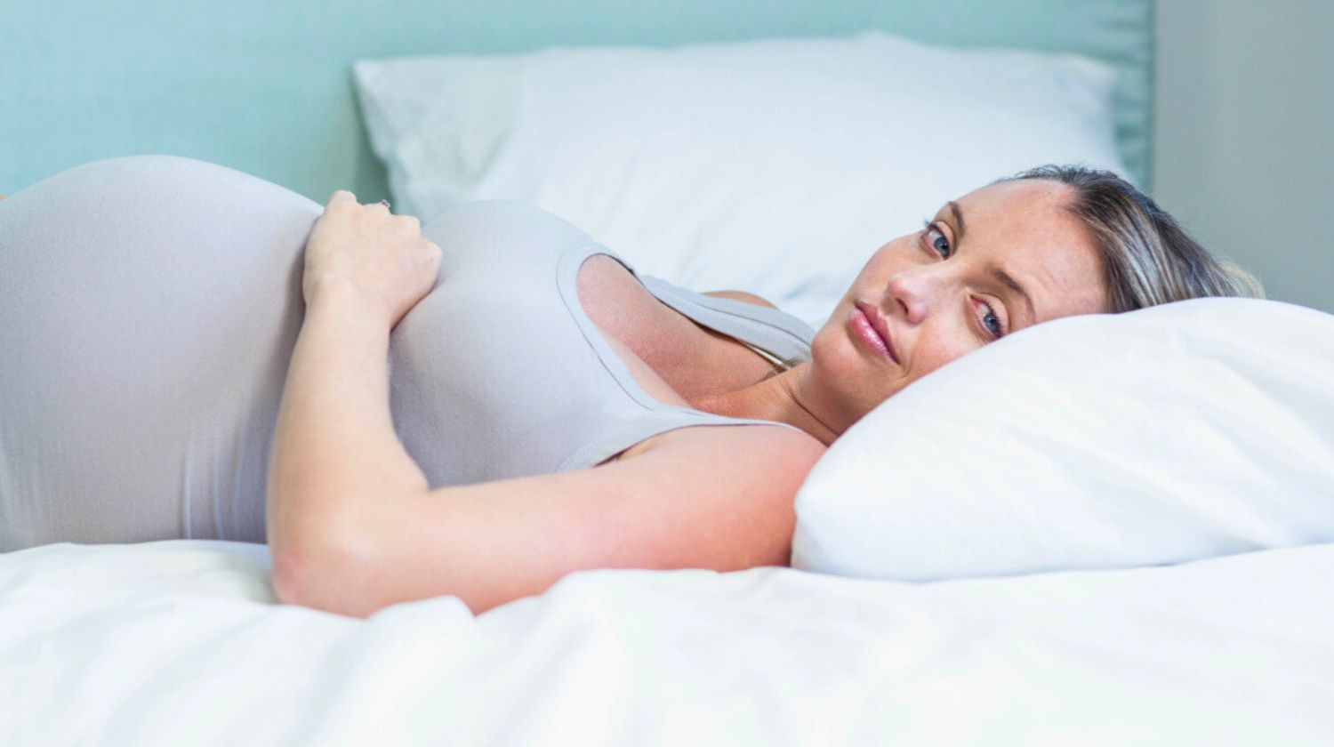 Trudnica lezi na belom jastuku