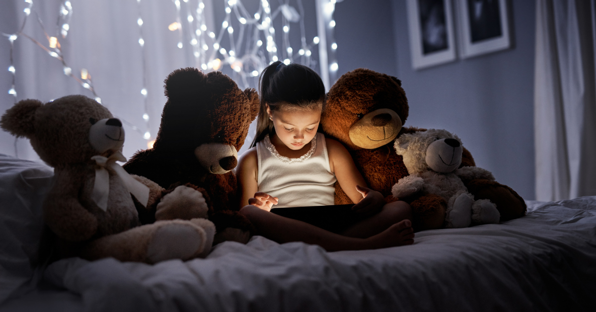 Devojčica uveče gleda u ekran tableta