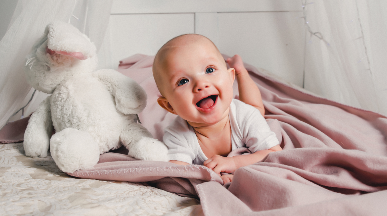 Beba leži na stomaku i smeje se