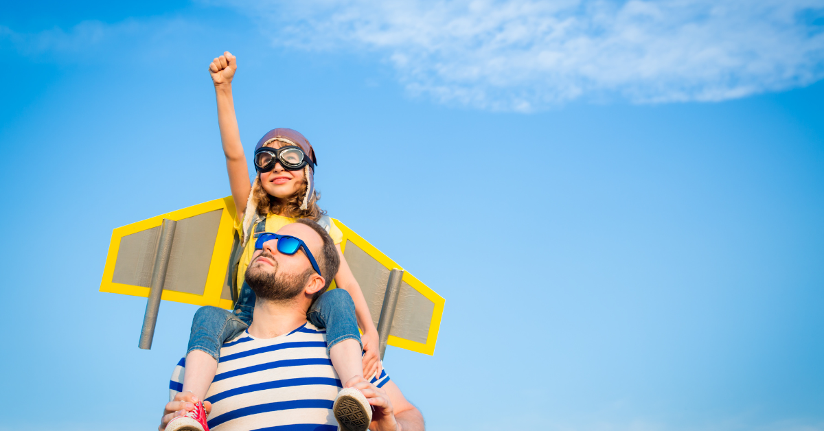 ćerka sedi tati na ramenima