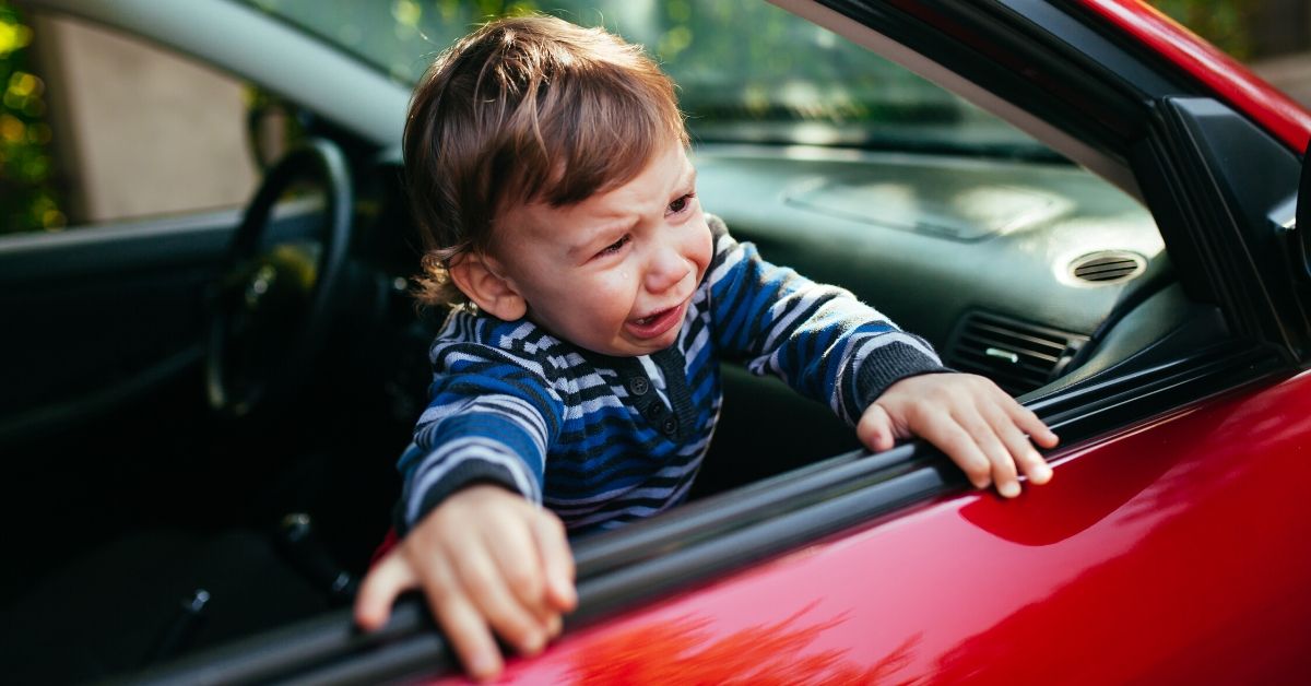 Dete plače i gleda kroz otvoren prozor automobila