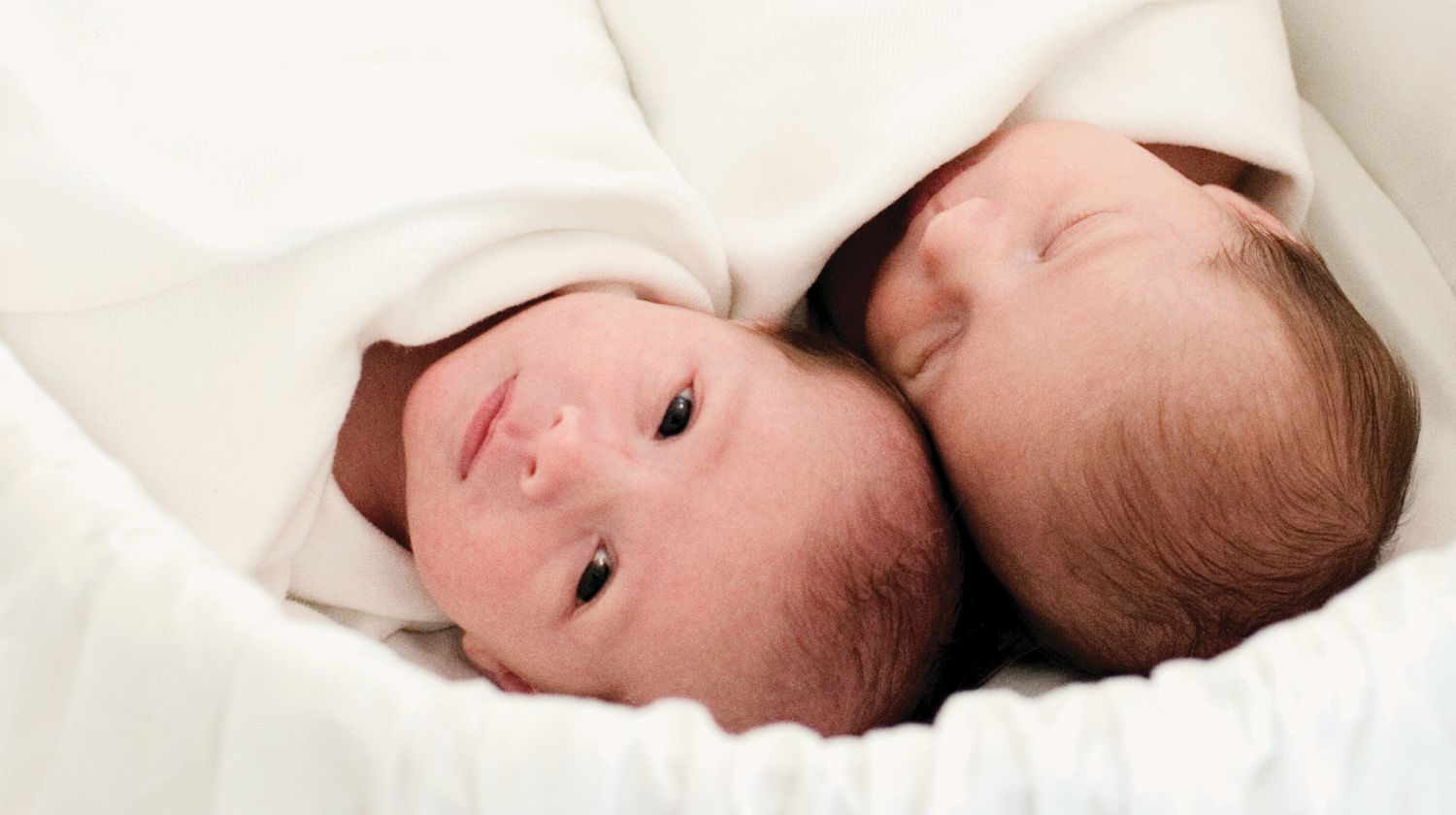 Blizanci dve bebe leže jedna pored druge