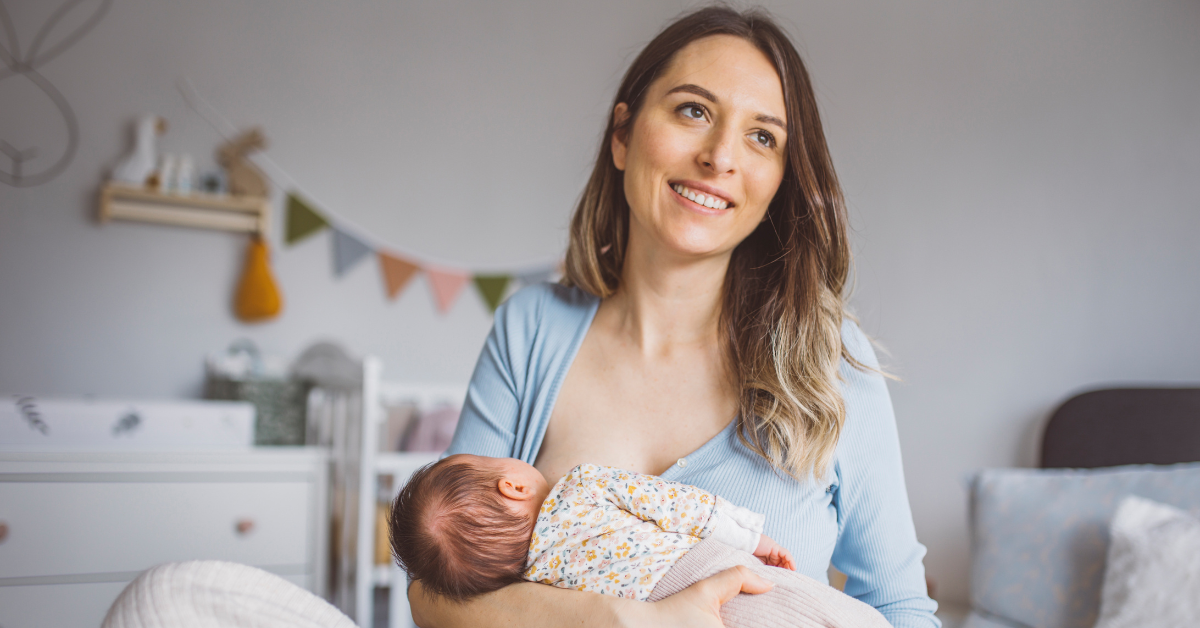 mama drži bebu u naručju i doji