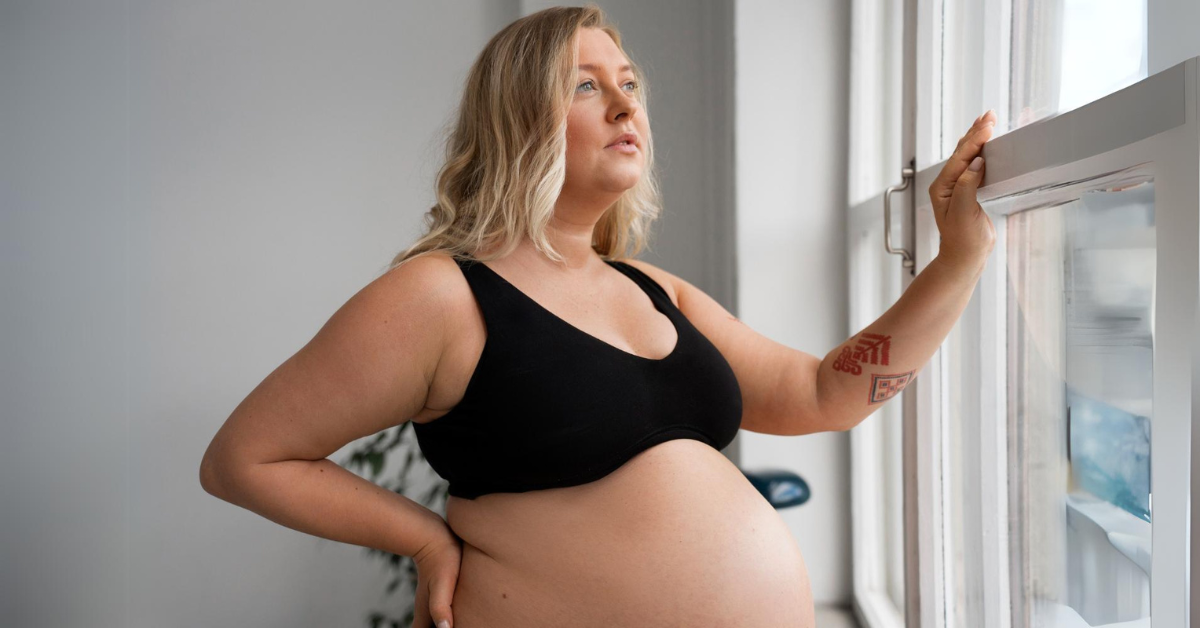 starija trudnica gleda kroz prozor