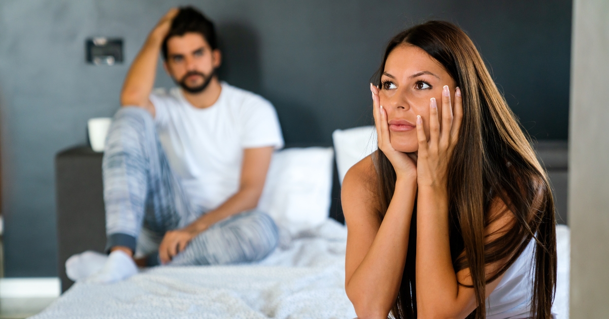 muškarac i zamišljena žena sede na krevetu