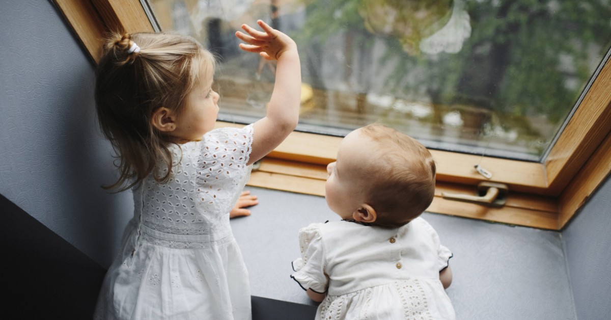 beba i devojčica kod prozora
