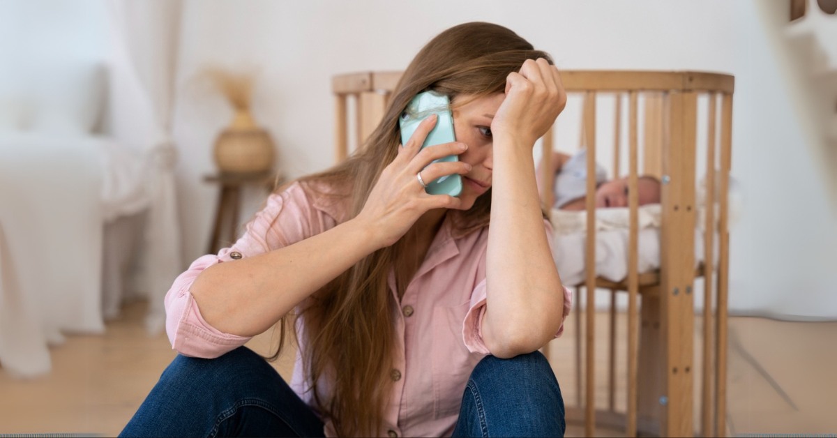 mama priča na telefon dok je beba u kolevci