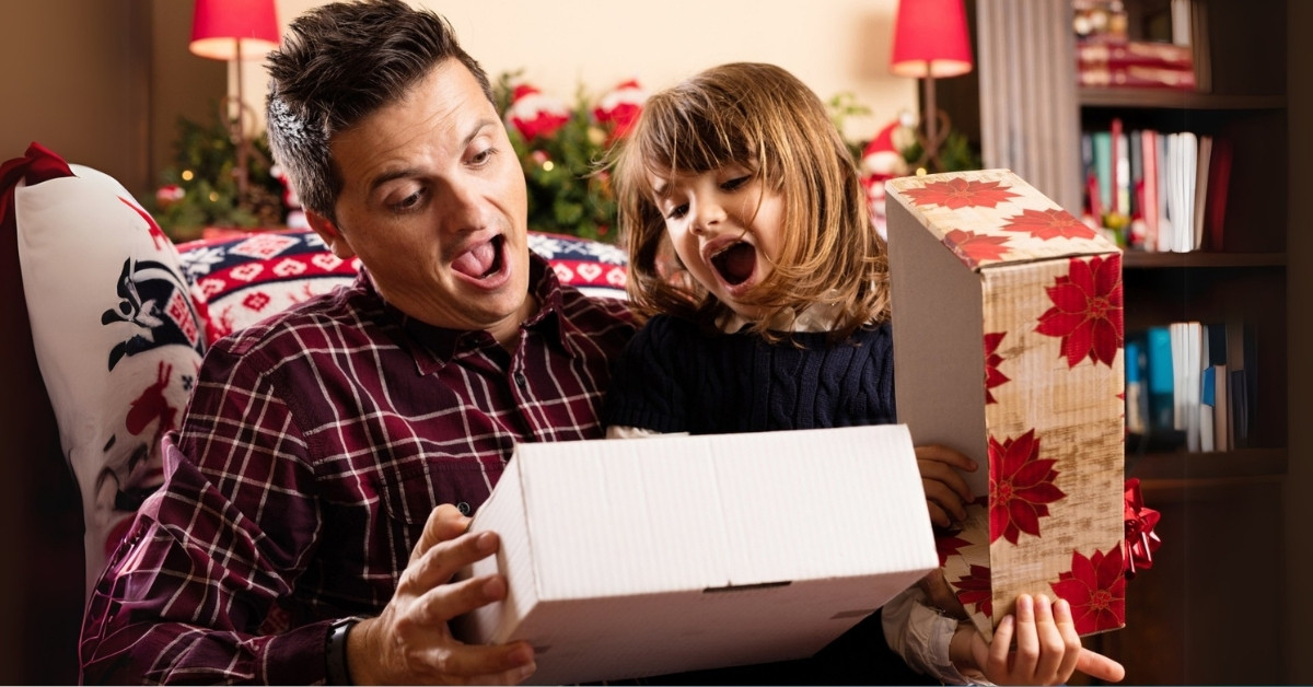 tata otvara novogodišnji poklon sa ćerkom