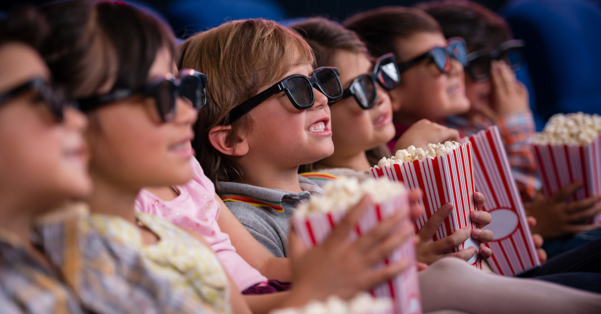 deca sede u bioskopu jedu kokice i gledaju film