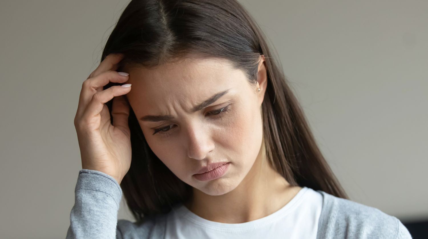 Namrštena žena sa rukom na čelu