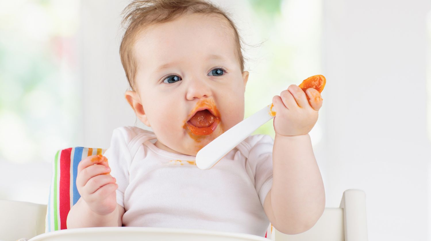 Musava beba drži kašičicu u ruci