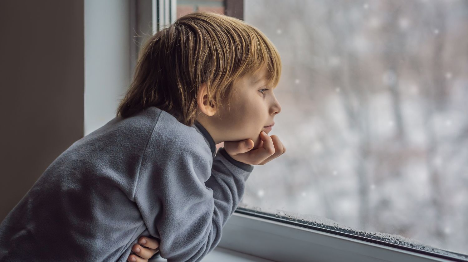Dečak gleda kroz prozor