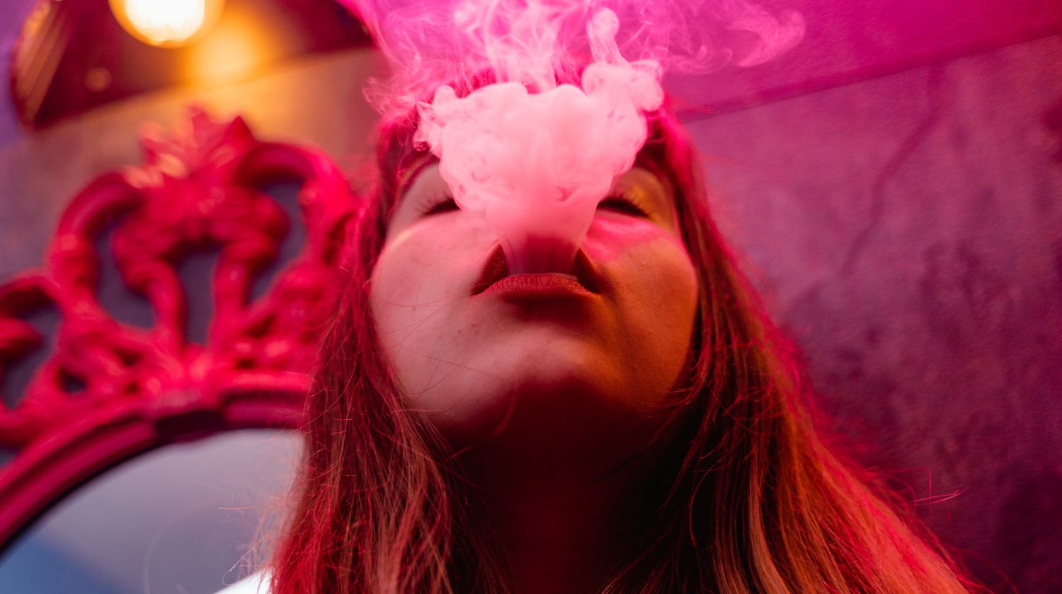 Devojka izduvava dim od cigarete