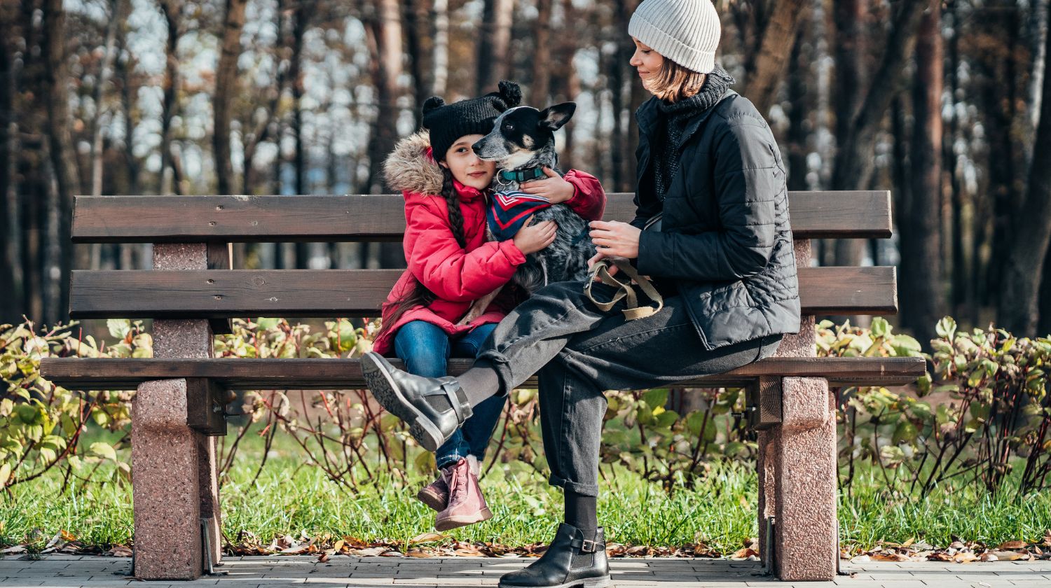 Mama, devojčica i pas na klupi