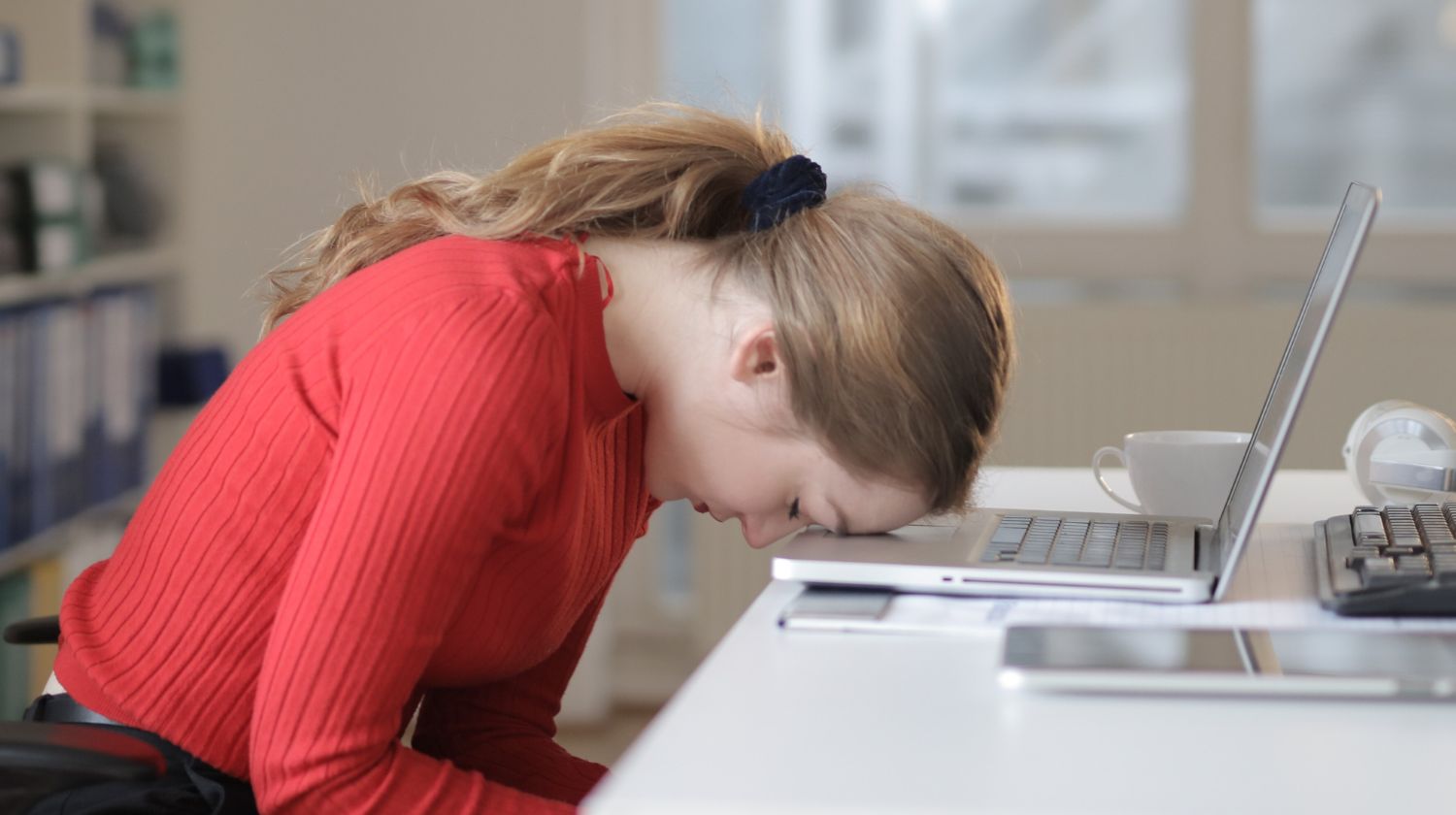 Žena glava na tastaturi otvoren laptop umor