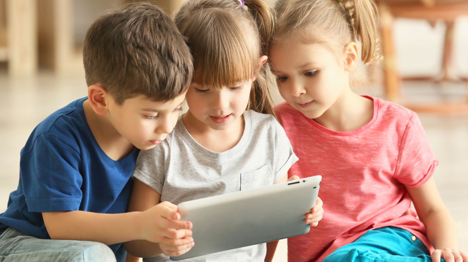 Dečak i dve devojčice gledaju u tablet