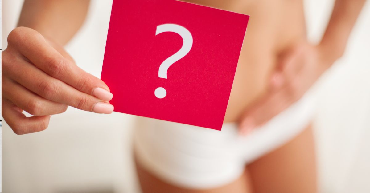 Žena se drži za stomak i pokazuje upitnik