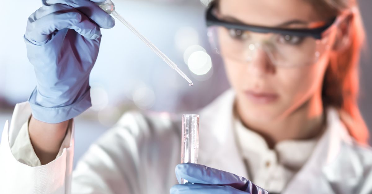 Naučnica drži epruvetu i pipetu