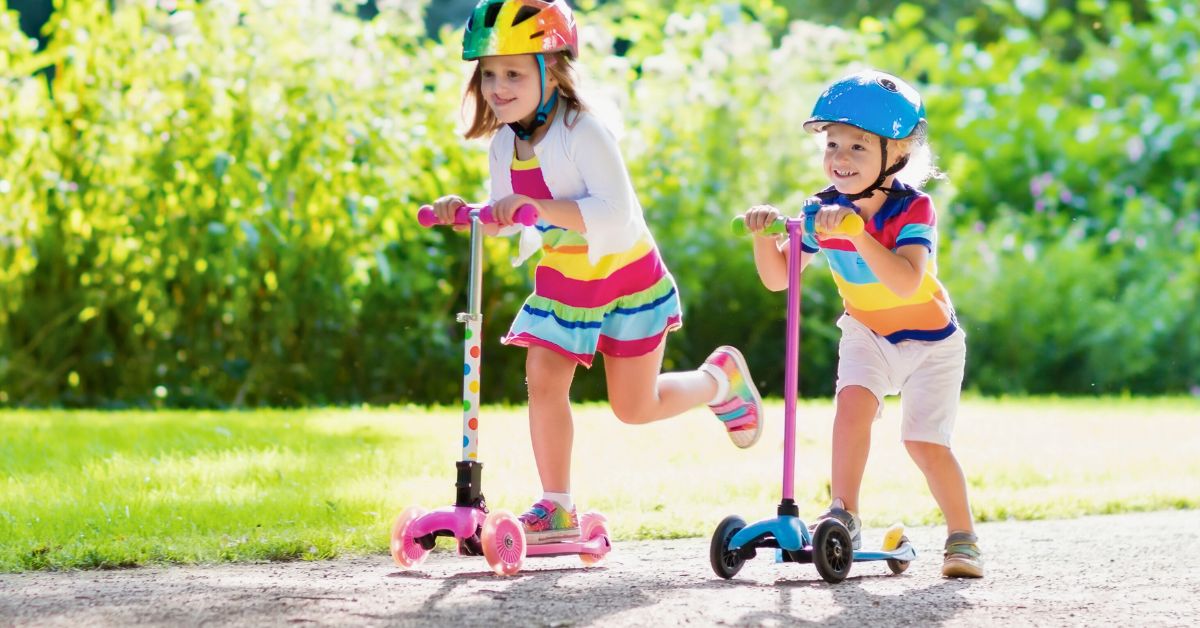 Ddečak i devojčica voze trotinet