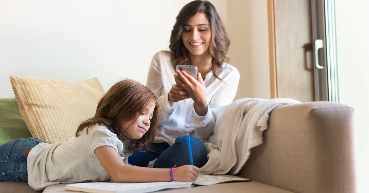 Mama gleda u telefon ćerka crta