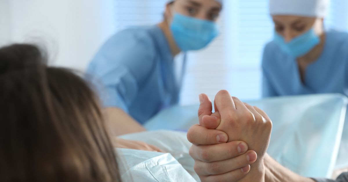 Žena leži i porađa se babice