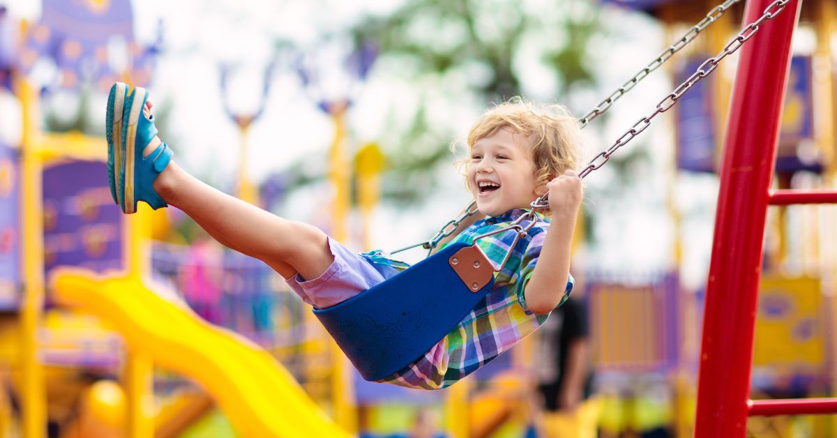 Dete se ljulja na ljuljašci u parku