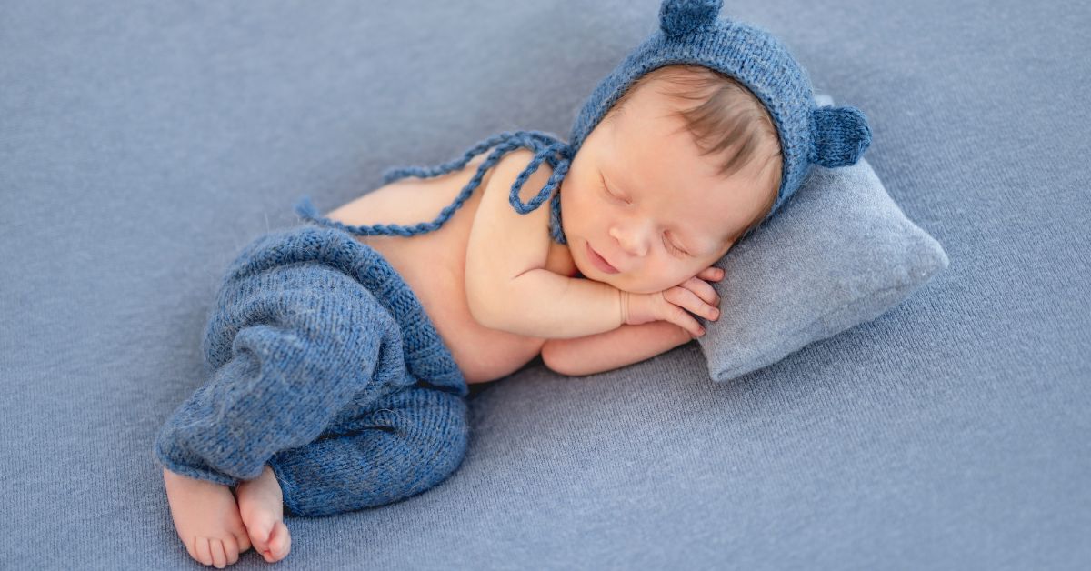 Novorođenče spava sa kapom sa ušima i pantalonicama