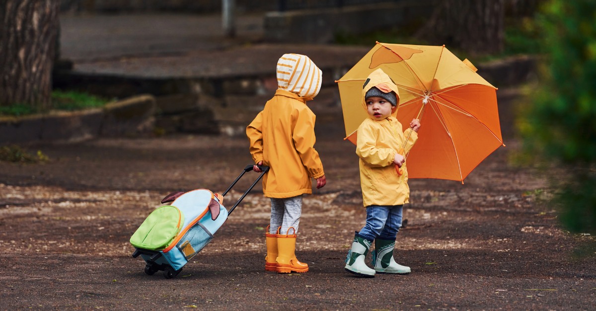 deca u kabanicama i kišobranima sa čizmicama