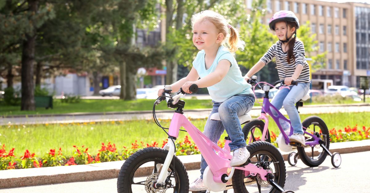 Dve devojčice voze bicikl napolju