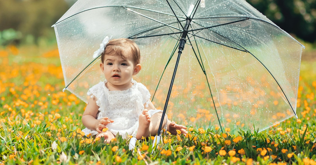 devojčica sedi u cveću na na poljani
